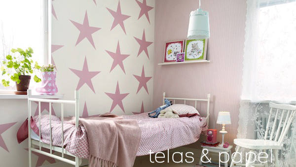 dormitorio con papel pintado infantil de enormes estrellas rosas
